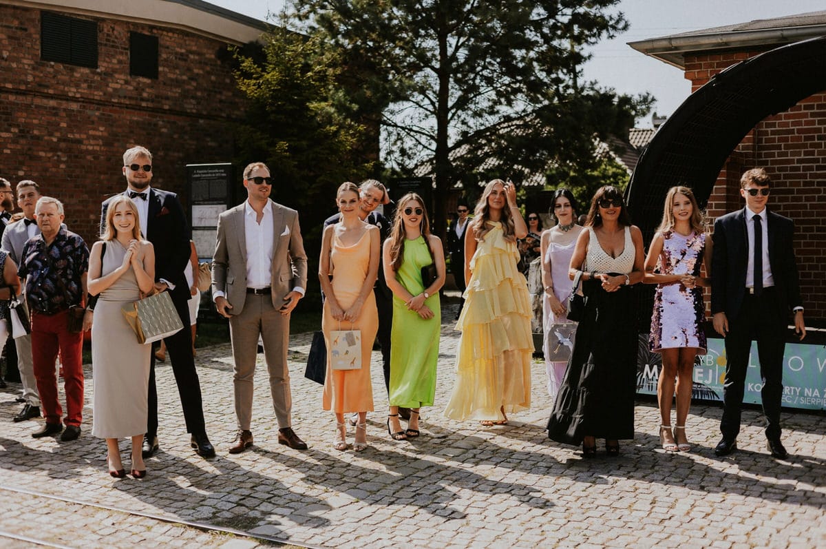 Grupa ludzi w eleganckich strojach na zewnątrz.