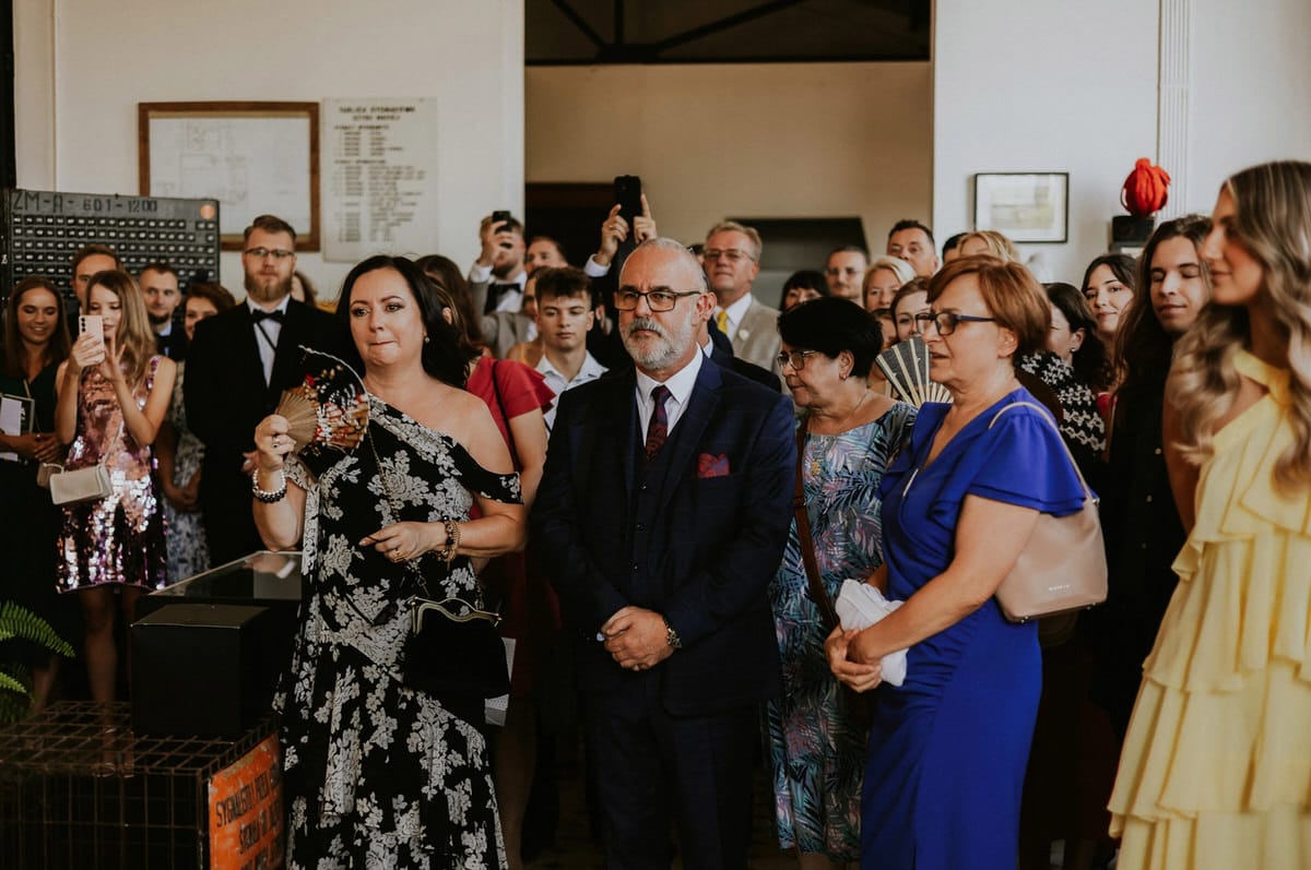 Grupa gości na uroczystości, eleganckie stroje.