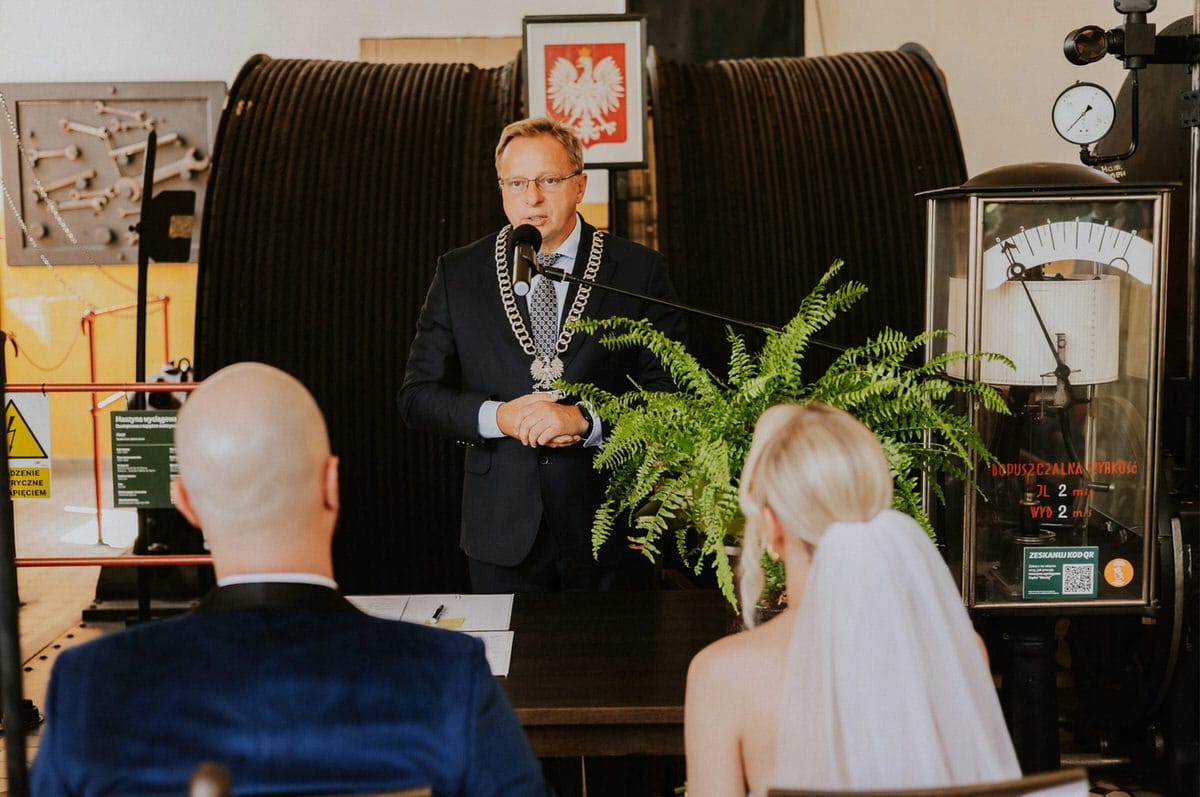 Ceremonia ślubna w industrialnym wnętrzu, przemawiający urzędnik.