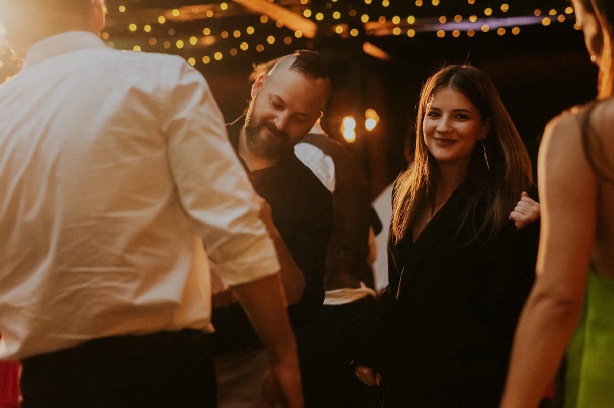Ludzie tańczą na przyjęciu z lampkami.