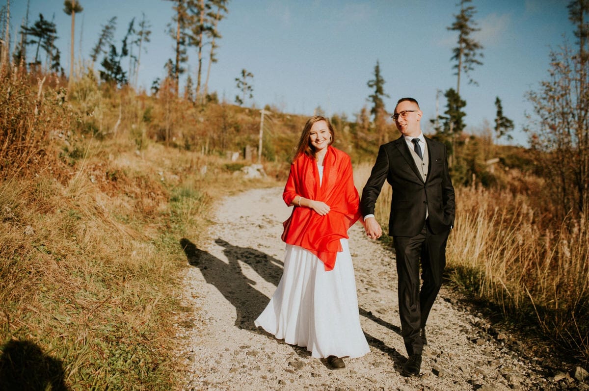Para w eleganckich strojach spaceruje po ścieżce